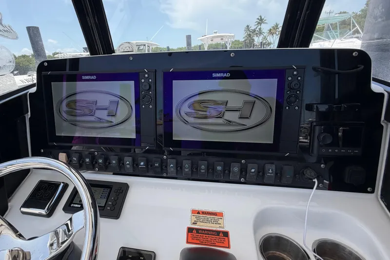 Slide: The Image of 2019 Sea Hunt Gamefish 27 dashboard with dual Simrad displays and control panel. - 25