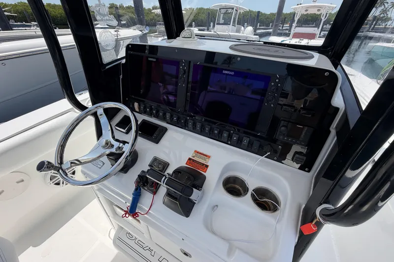 Slide: The Image of 2019 Sea Hunt Gamefish 27 Coffin Box boat console with steering wheel and navigation system. - 13