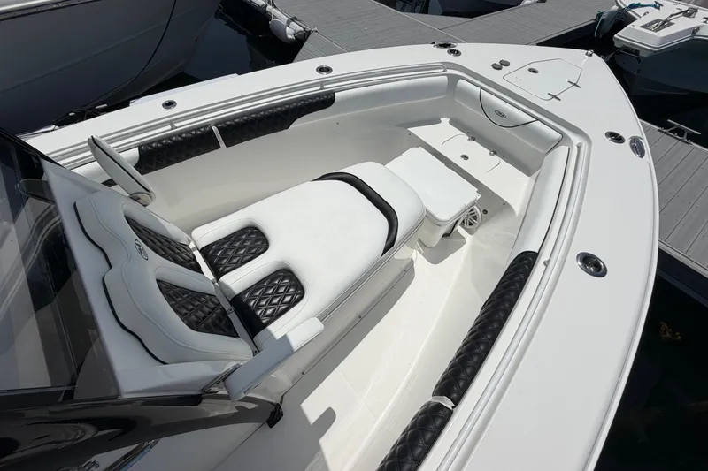 Slide: The Image of 2019 Sea Hunt Gamefish 27 Coffin Box boat interior with cushioned seating and storage. - 16