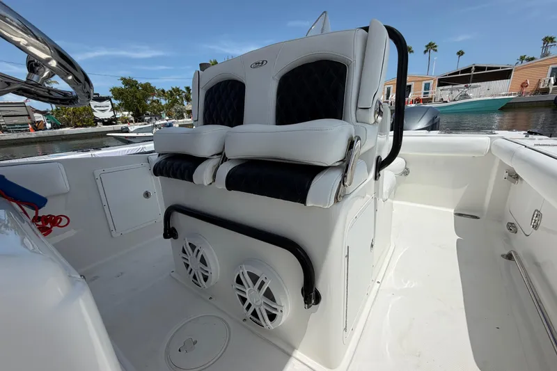 Slide: The Image of 2019 Sea Hunt Gamefish 27 Coffin Box boat interior with cushioned seating and speakers. - 34