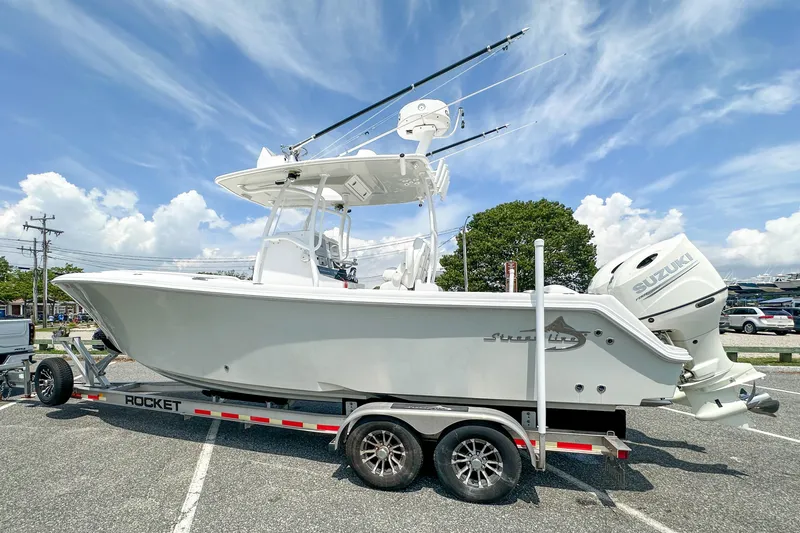 Slide: The Image of 2019 Streamline 26 TE boat on trailer with Suzuki outboard, parked under a clear blue sky. - 56
