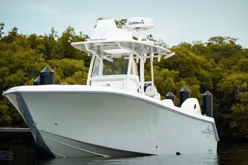 The Image of 2019 Streamline 26 TE boat docked, featuring Garmin equipment, surrounded by lush greenery. - 1