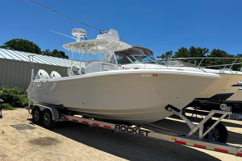 Slide: The Image of 2019 Streamline 26 TE boat on trailer, parked outdoors under clear blue sky. - 2