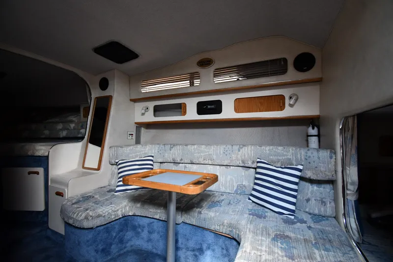 Slide: The Image of Interior of a 1993 Sea Ray 300 Sundancer boat with cozy seating and striped pillows. - 24