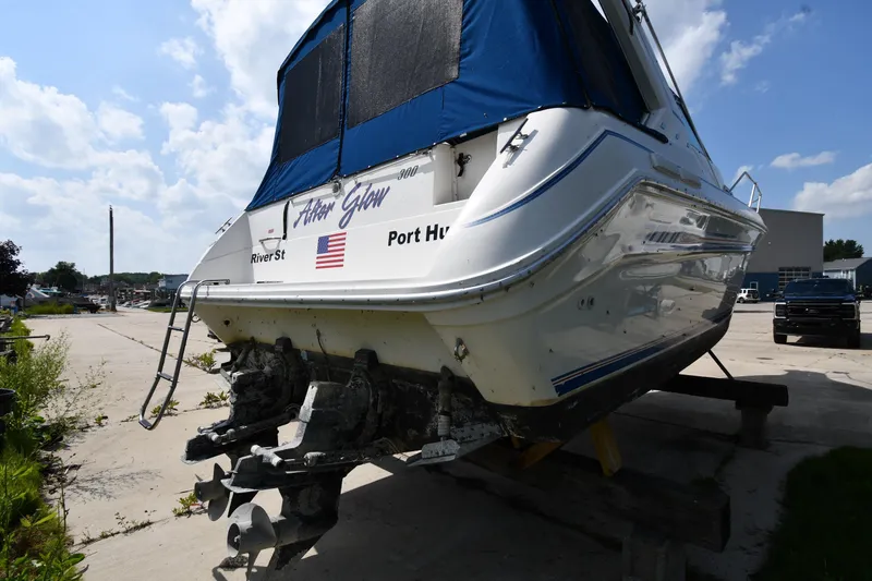 Slide: The Image of 1993 Sea Ray 300 Sundancer boat on dry dock, featuring blue canopy and dual propellers. - 7