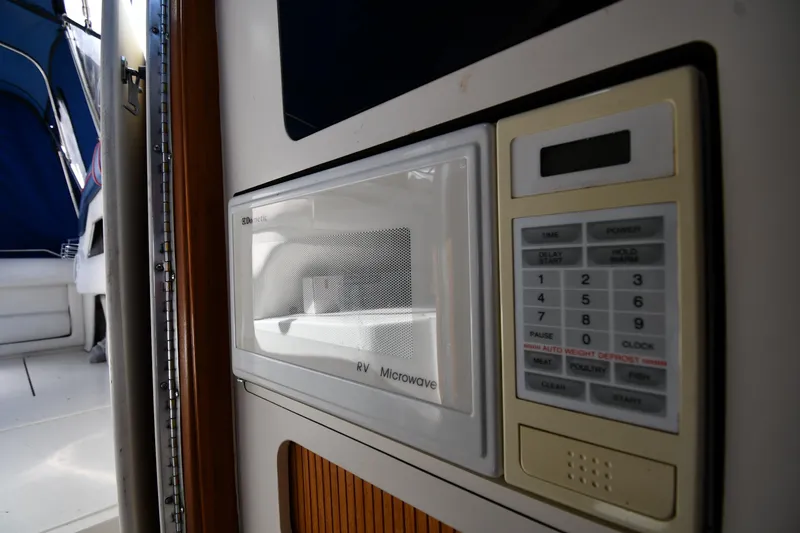 Slide: The Image of Microwave inside 1993 Sea Ray 300 Sundancer boat, featuring control panel and interior view. - 33