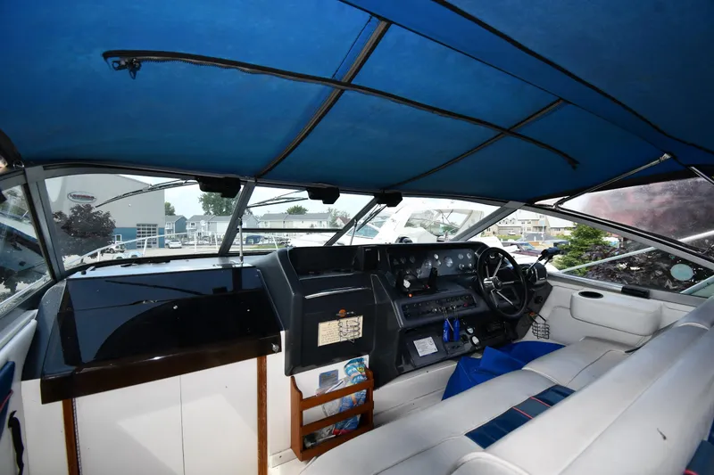 Slide: The Image of Interior view of a 1993 Sea Ray 300 Sundancer boat cockpit with blue canopy. - 10