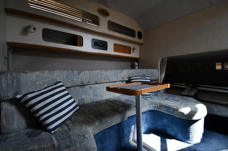 Slide: The Image of Interior of 1993 Sea Ray 300 Sundancer with cozy seating and striped pillows. - 27
