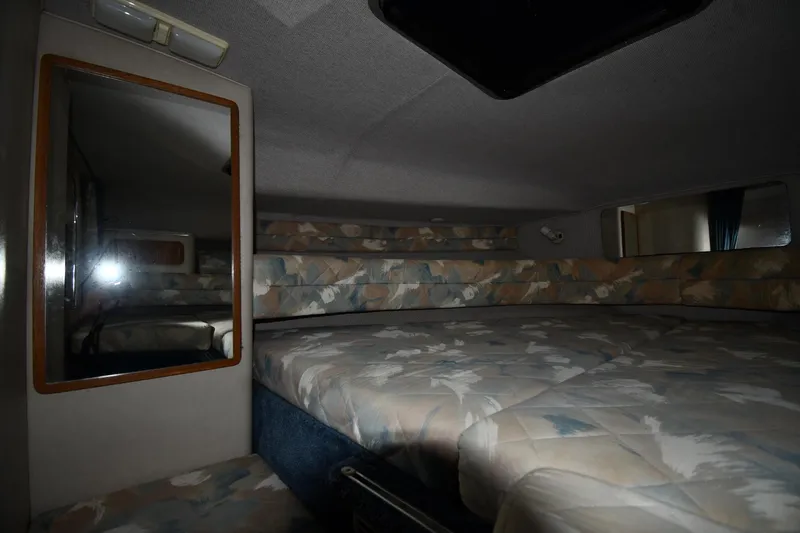 Slide: The Image of Interior cabin of 1993 Sea Ray 300 Sundancer with patterned bedding and mirror. - 21