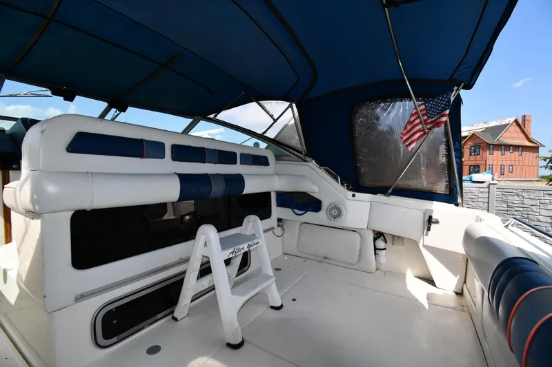 Slide: The Image of 1993 Sea Ray 300 Sundancer interior with blue canopy and American flag. - 13