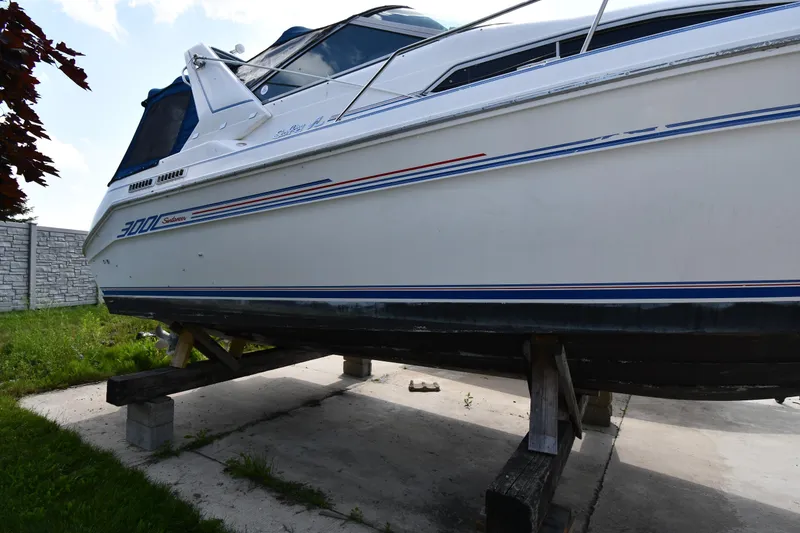 Slide: The Image of 1993 Sea Ray 300 Sundancer boat on wooden supports, side view. - 5