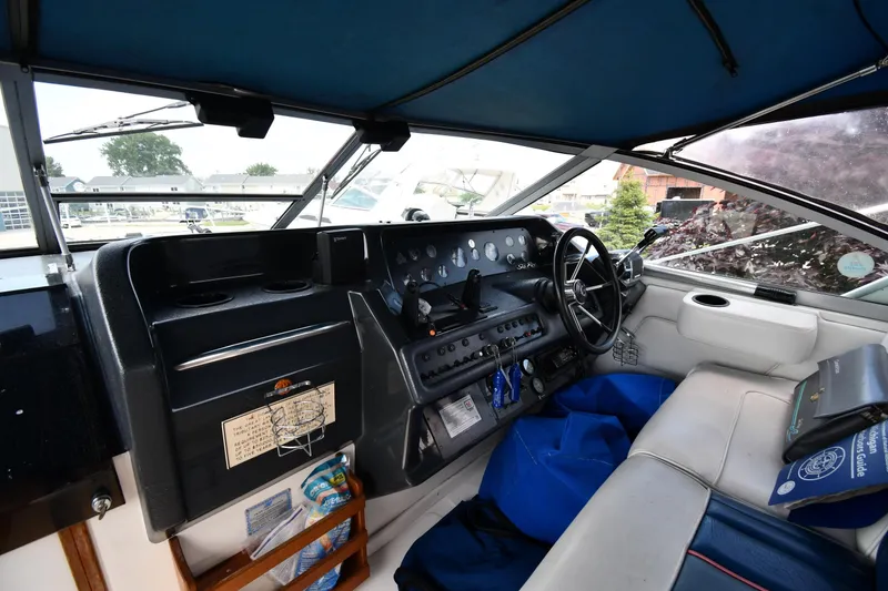 Slide: The Image of 1993 Sea Ray 300 Sundancer cockpit with steering wheel, dashboard, and seating area. - 11