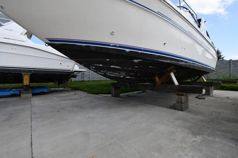 Slide: The Image of 1993 Sea Ray 300 Sundancer boat on dry dock, showing hull and support structure. - 2