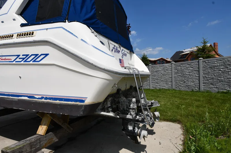 Slide: The Image of 1993 Sea Ray 300 Sundancer boat on land, showing stern and propellers. - 8