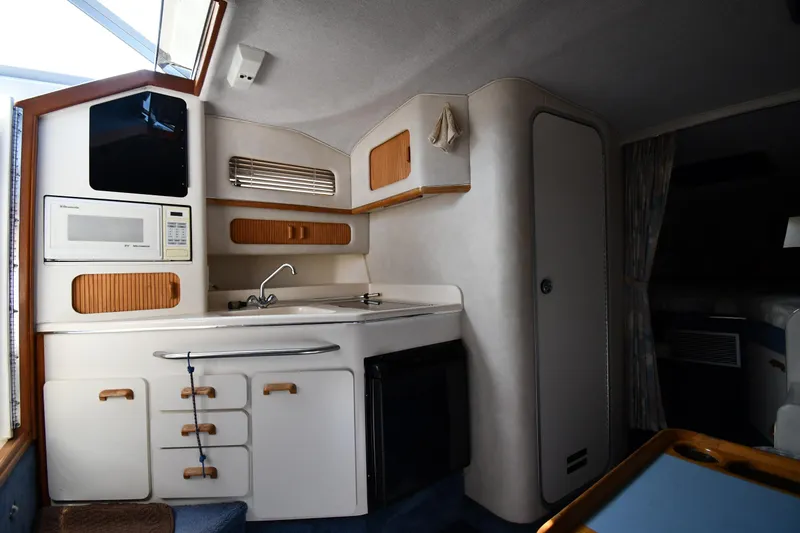 Slide: The Image of Interior of 1993 Sea Ray 300 Sundancer boat featuring a compact kitchen area. - 25