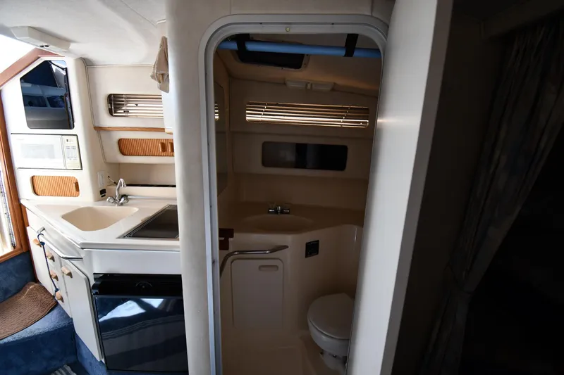 Slide: The Image of Interior of 1993 Sea Ray 300 Sundancer showing kitchenette and compact bathroom. - 28