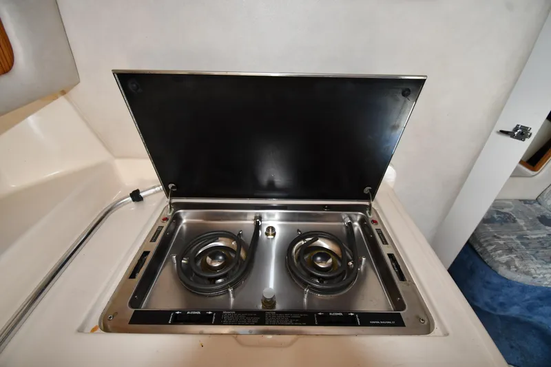 Slide: The Image of 1993 Sea Ray 300 Sundancer boat stove with two burners in cabin kitchen area. - 32
