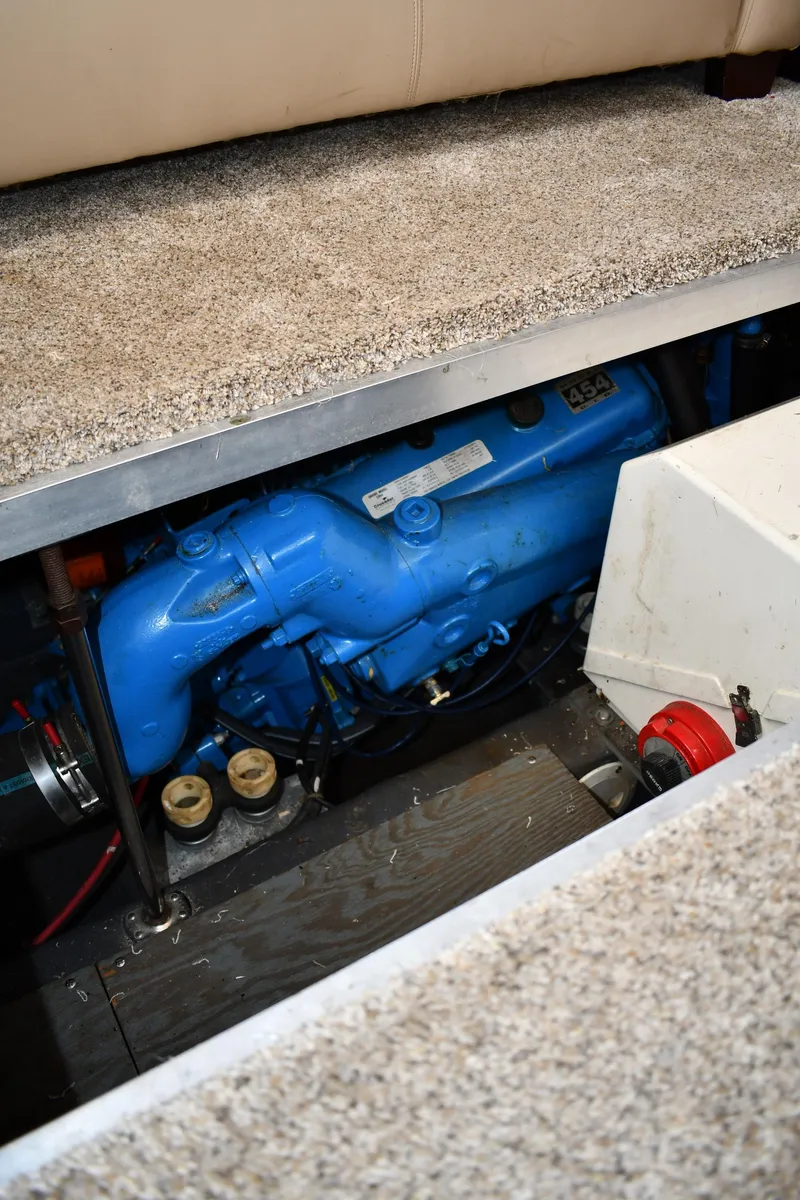 Slide: The Image of An engine compartment with a blue engine, surrounded by carpeted flooring. - 49