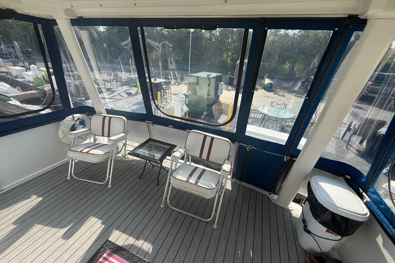 Slide: The Image of 1992 Carver 33 Aft Cabin Motor Yacht interior with seating and table, featuring large windows. - 17