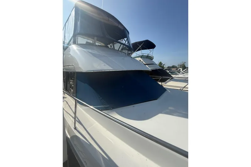 Slide: The Image of 1992 Carver 33 Aft Cabin Motor Yacht with sleek design, docked under clear blue sky. - 4