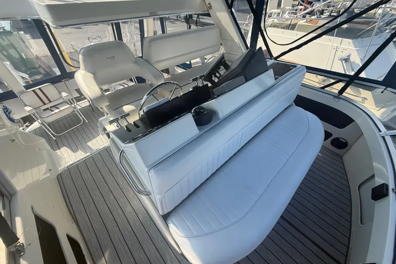 Slide: The Image of 1992 Carver 33 Aft Cabin Motor Yacht cockpit with white seating and steering wheel. - 25