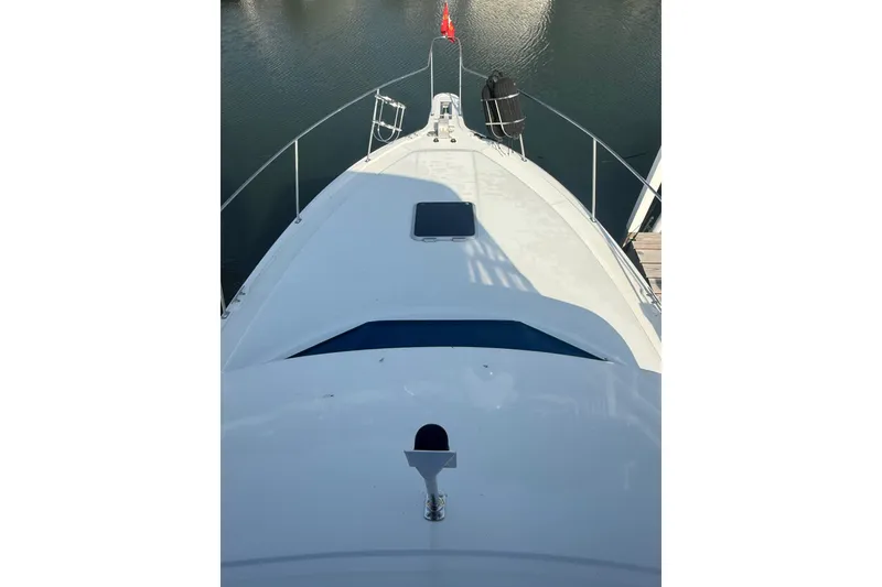 Slide: The Image of 1992 Carver 33 Aft Cabin Motor Yacht bow view, docked on calm water. - 10