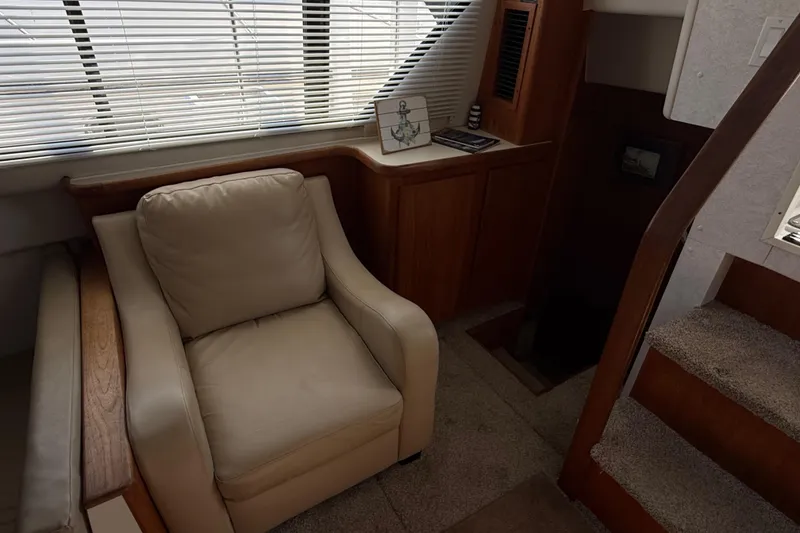 Slide: The Image of Interior of 1992 Carver 33 Aft Cabin Motor Yacht with beige armchair and wooden accents. - 30