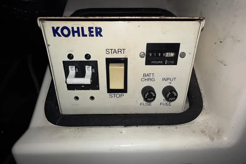 Slide: The Image of Kohler control panel on 1992 Carver 33 Aft Cabin Motor Yacht, featuring switches and hour meter. - 54
