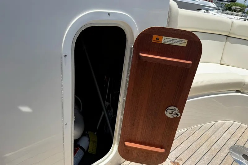Slide: The Image of Open storage compartment on a 2005 Chris-Craft Launch 28 boat with wooden door. - 28