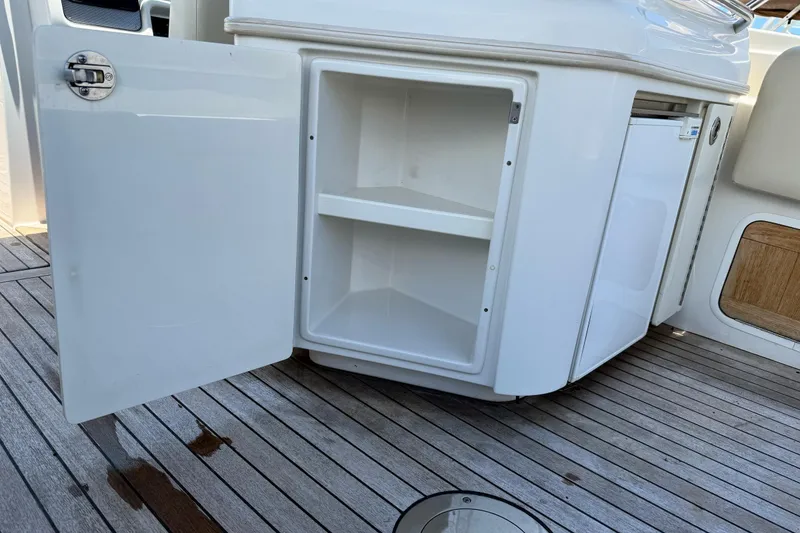Slide: The Image of Open storage compartment on 2005 Chris-Craft Launch 28 boat with wooden deck. - 34