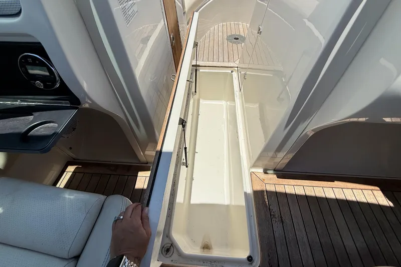 Slide: The Image of Open storage compartment on 2005 Chris-Craft Launch 28 boat with wooden deck. - 31
