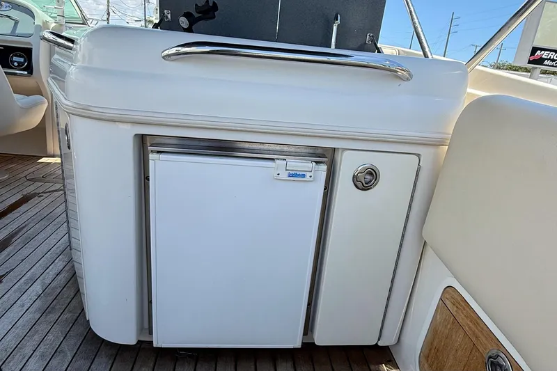 Slide: The Image of 2005 Chris-Craft Launch 28 boat interior with mini fridge and wooden deck. - 36