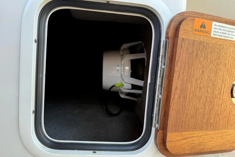 Slide: The Image of Storage compartment on a 2005 Chris-Craft Launch 28 boat with a warning label. - 33