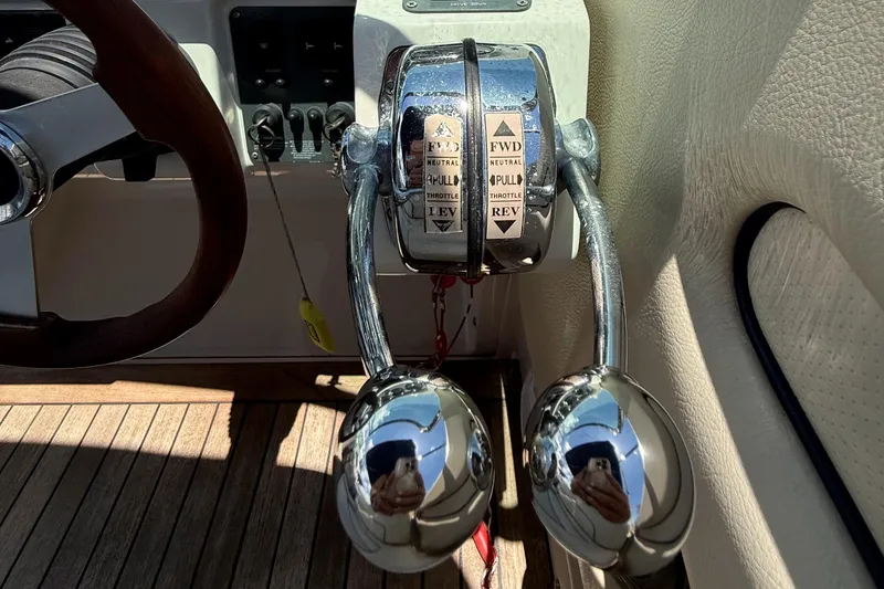 Slide: The Image of 2005 Chris-Craft Launch 28 throttle controls and steering wheel on wooden deck. - 16
