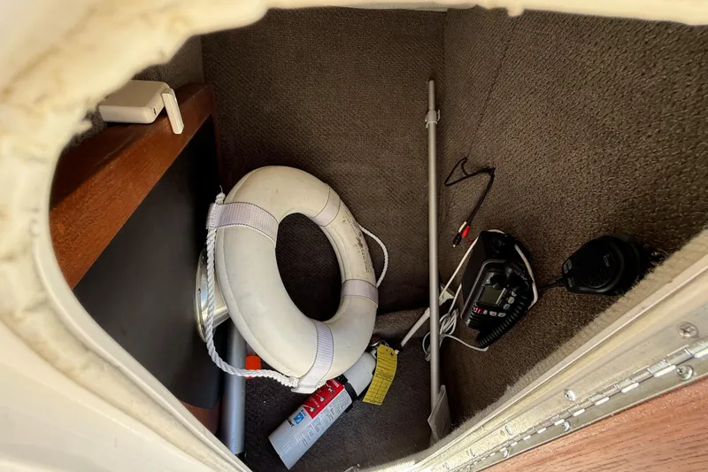 Slide: The Image of Storage compartment of a 2005 Chris-Craft Launch 28 with safety equipment and radio. - 29