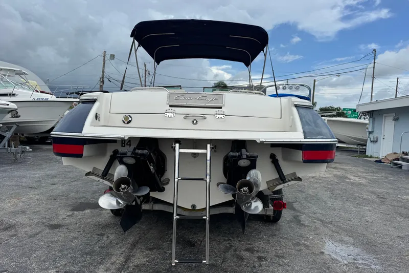 Slide: The Image of 2005 Chris-Craft Launch 28 boat, rear view with dual propellers and canopy, parked outdoors. - 2