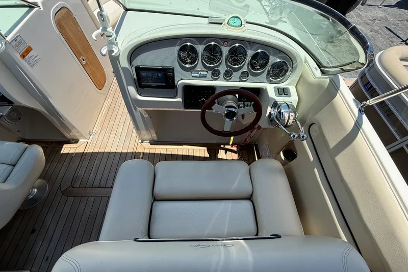 Slide: The Image of 2005 Chris-Craft Launch 28 boat cockpit with steering wheel, gauges, and wooden flooring. - 10