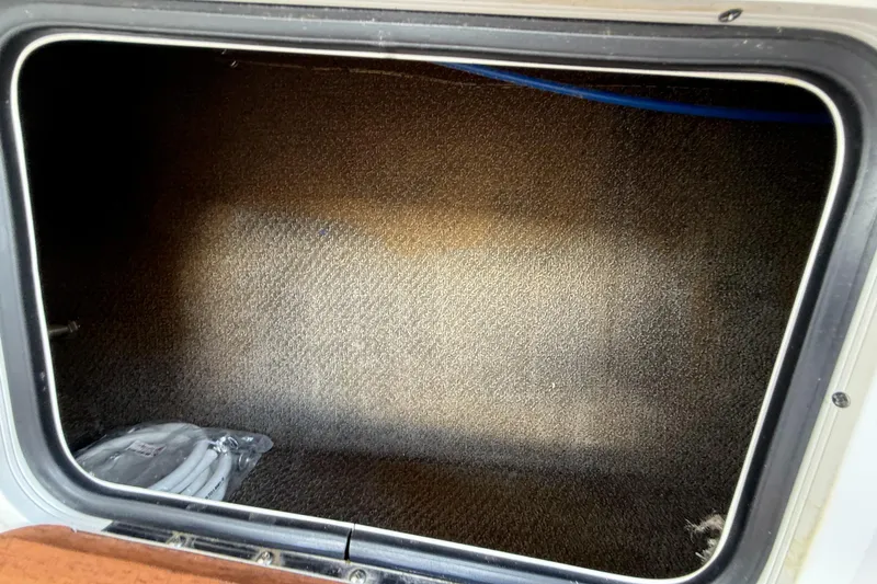 Slide: The Image of Storage compartment of a 2005 Chris-Craft Launch 28 boat, featuring carpeted interior. - 39