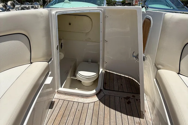 Slide: The Image of 2005 Chris-Craft Launch 28 boat interior with open bathroom door, showcasing toilet and seating. - 24