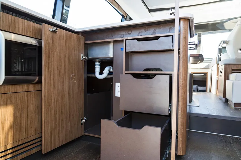 Slide: The Image of Manufacturer Provided Image: 2018 Sea Ray Fly 460 kitchen storage with open cabinets and drawers. - 9