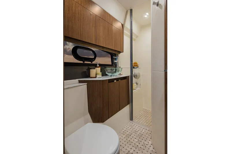 Slide: The Image of Manufacturer Provided Image: Modern bathroom in 2018 Sea Ray Fly 460 yacht with glass sink and wooden cabinets. - 17
