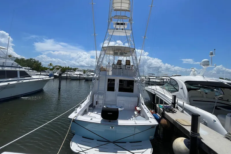 Slide: The Image of 1990 Hatteras 45 Convertible yacht docked at marina under clear blue sky. - 24
