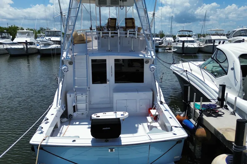 Slide: The Image of 1990 Hatteras 45 Convertible yacht docked at marina under blue sky. - 22