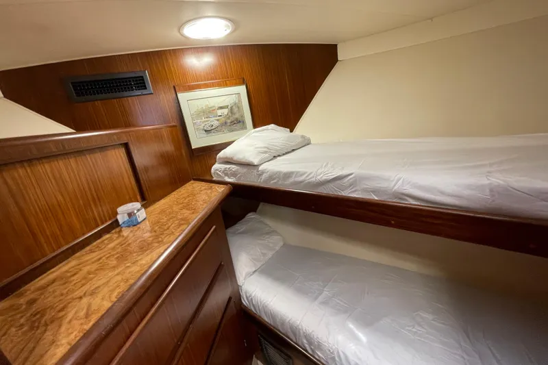 Slide: The Image of Interior of 1990 Hatteras 45 Convertible yacht with wooden bunk beds and artwork. - 73