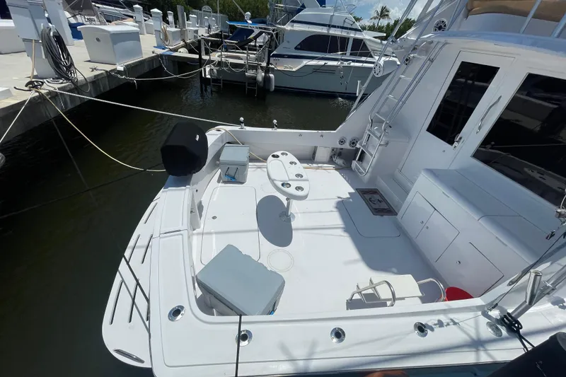 Slide: The Image of 1990 Hatteras 45 Convertible yacht docked, featuring spacious deck and seating area. - 29
