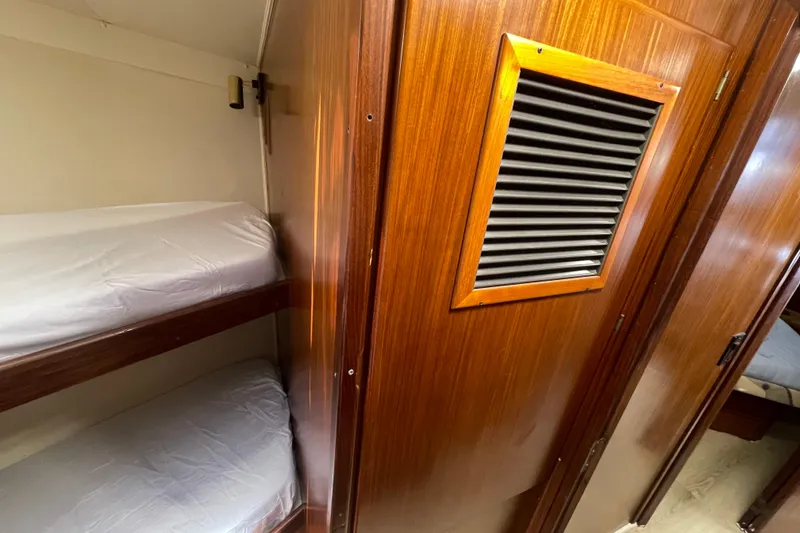 Slide: The Image of Interior of 1990 Hatteras 45 Convertible yacht with wooden paneling and bunk beds. - 74