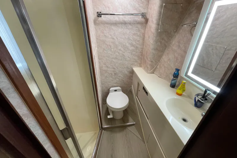 Slide: The Image of Bathroom interior of 1990 Hatteras 45 Convertible yacht, featuring shower, toilet, and sink. - 61