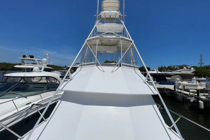 Slide: The Image of 1990 Hatteras 45 Convertible yacht docked, showcasing sleek design and spacious deck. - 48