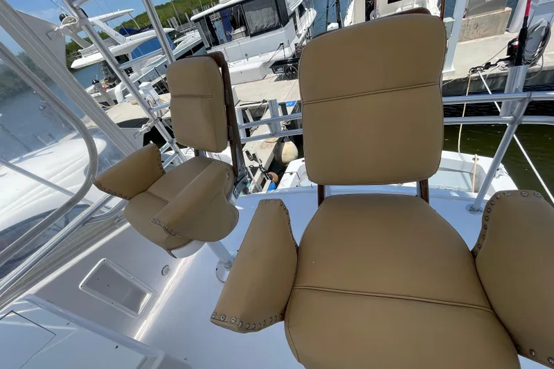 Slide: The Image of Luxury seating on a 1990 Hatteras 45 Convertible yacht, docked at a marina. - 35