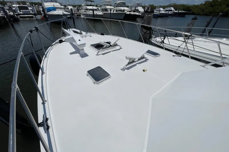 Slide: The Image of 1990 Hatteras 45 Convertible yacht deck view at marina, showcasing sleek design and spacious layout. - 41